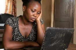 Woman Contemplating beside a broken laptop